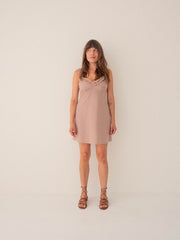 Woman wearing a pink dress against a plain background