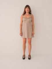 Woman wearing a patterned dress against a plain background